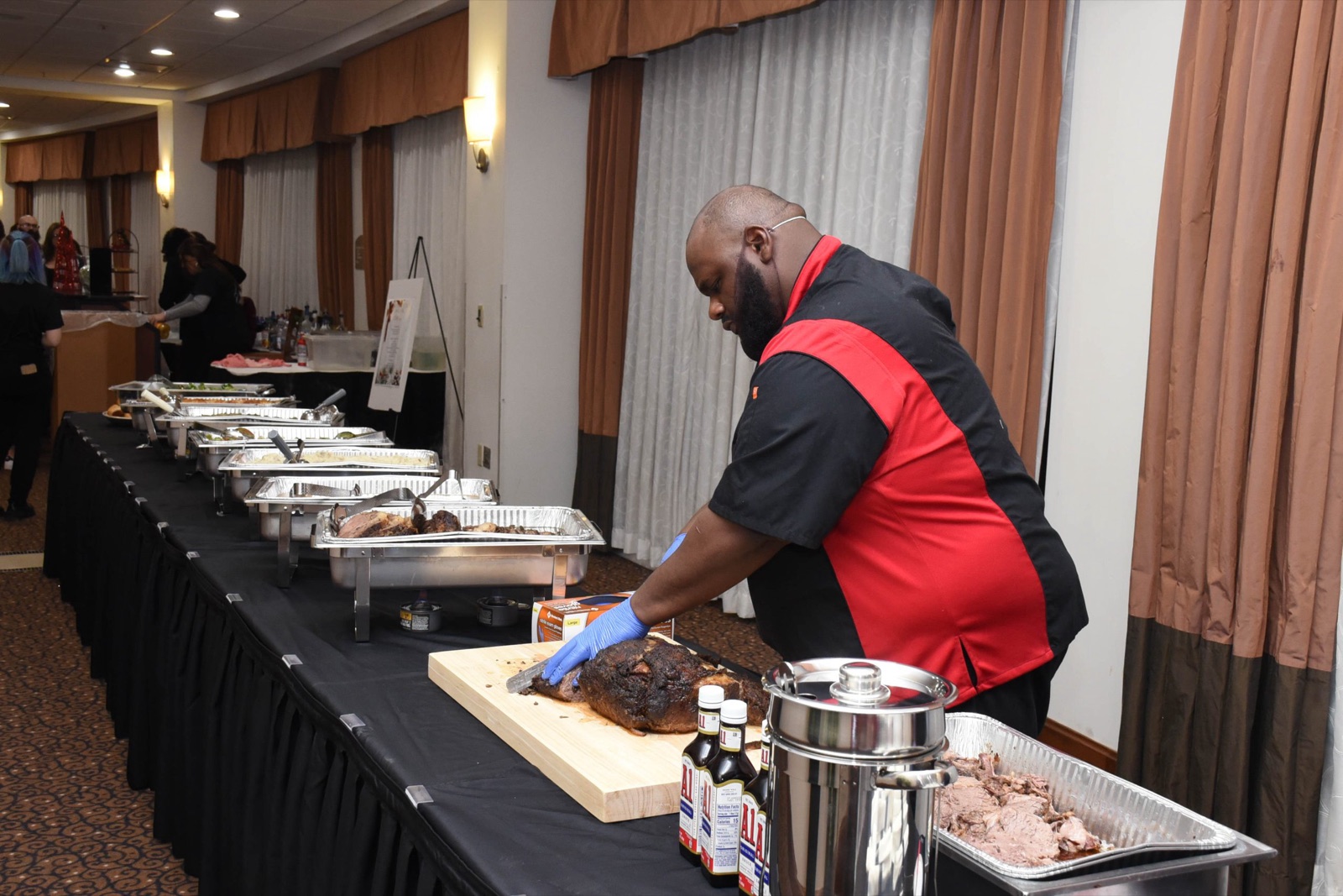 Chef Benny carving brisket at a catering event
